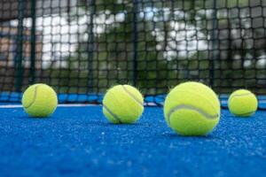 selectief focus, vier ballen Aan een peddelen tennis rechtbank met de netto in de achtergrond foto