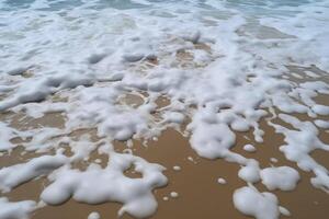 zanderig strand gewassen door zee water met schuim foto