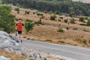 vastbesloten atleet rennen door robuust berg terrein Bij zonsopkomst. foto