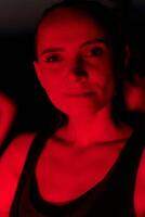 atleet stakingen een houding in rood verlicht 's nachts gloed foto
