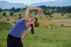 vastbesloten rekken. atletisch vrouw omarmt post-run flexibiliteit in natuur. foto