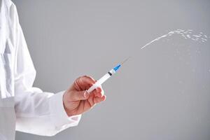 de dokter houdt een injectiespuit met geneesmiddel. detailopname. foto