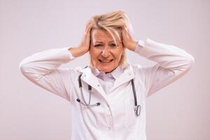 portret van overwerkt volwassen vrouw dokter schreeuwen Aan grijs achtergrond. foto