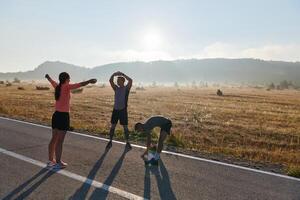 verschillend atleten bereiden. dynamisch groep verwarmt omhoog voor ochtend- rennen. foto