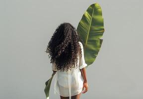 vrouw met groot groen blad Aan haar terug foto