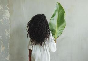 vrouw met groot groen blad Aan haar terug foto