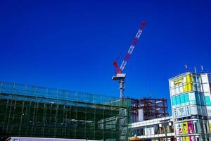 in beweging kranen achter de blauw lucht Bij de onder bouw in tokyo foto