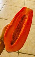 voor de helft papaja in hand- met achtergrond in Mexico. foto