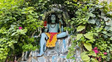 Hindoe god mahadev zittend in grot met trishul foto