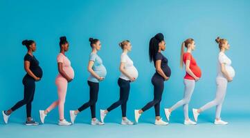 een groep van gelukkig zwanger Dames zijn staand in een lijn vervelend een verschillend gekleurde kleding foto