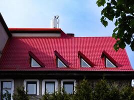 rood betegeld dak met driehoekig ramen foto