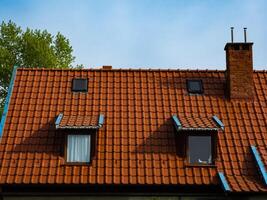 dak van een huis gemaakt van rood tegels met een schoorsteen en zolder foto