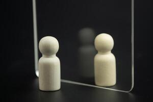 houten pin poppen staand staan op zoek door transparant glas. reflecties Aan vooruitzichten. foto