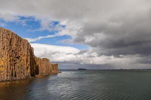 panorama van een basalt klif overhangend de zee in IJsland foto