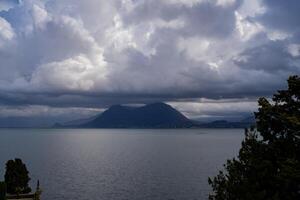 panorama van meer maggiore Aan een regenachtig dag met zwaar laag wolken aan het bedekken een deel van de kust foto