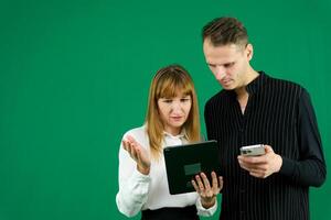 jong paar twee vrienden familie Mens vrouw in roze kleren samen houden in hand- gebruik mobiel cel telefoon punt Aan het zeggen Wauw zoeken geïsoleerd Aan pastel duidelijk licht blauw kleur achtergrond studio portret foto