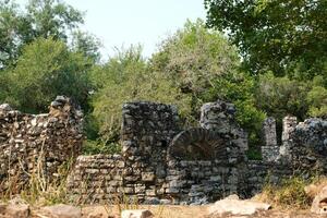 ruïnes van de Super goed basiliek in maarrint nationaal park, butrotum, albanië. triconch paleis Bij maarrint leven en dood van een oude Romeins huis historisch middeleeuws Venetiaanse toren omringd foto