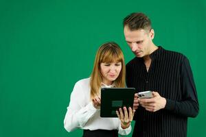 jong paar twee vrienden familie Mens vrouw in roze kleren samen houden in hand- gebruik mobiel cel telefoon punt Aan het zeggen Wauw zoeken geïsoleerd Aan pastel duidelijk licht blauw kleur achtergrond studio portret foto