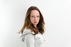 een heel streng niet tevreden kijken van een tiener- meisje draaide zich om haar hoofd in de kader keek streng mooi kapsel grijs met een kap sweater Aan een wit achtergrond foto