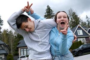 jongens meisje voor de gek houden in de omgeving van knuffelen plakken vingers vermaak tieners lachend knuffelen strijd broer en zus privaat sector Vancouver Canada Surrey tiener wolken het zullen regen wandelen buiten foto