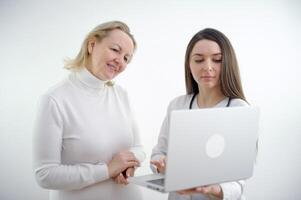 volwassen dokter en jong verpleegster met laptop Aan wit achtergrond, foto