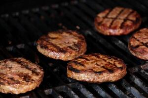 barbecueën fabriek gebaseerd onmogelijk hamburger pasteitjes Aan elektrisch rooster semi dichtbij omhoog schot pannen over- spatel omgedraaid en gegrild bruin gekruid hamburger pasteitjes foto