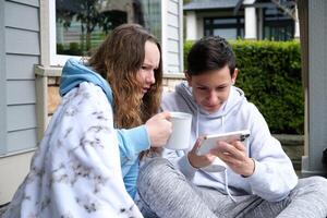 datum drinken thee Aan veranda tieners leren lessen verhogen mokken gedekt met deken zittend Turks stijl aktentas laptop mappen in sportschoenen joggingbroek in de buurt de venster Bij huis eerste liefde adolescentie foto