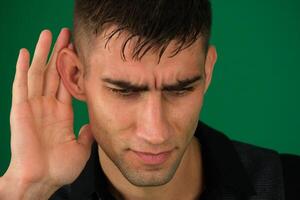 de doof jong Mens zetten zijn hand- naar zijn oor, luisterde. foto