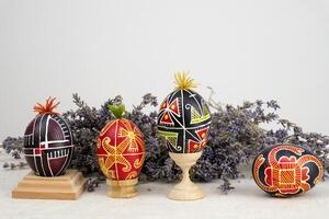 krashanka kruis banier ruimte voor reclame eigengemaakt hand- geschilderd Pasen eieren Aan houten staat Aan lavendel achtergrond droog bloemen Pasen foto