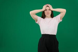 portret van bezorgd moe jong vrouw in groen gewoontjes kleren op zoek camera, zetten handen Aan hoofd geïsoleerd Aan helder blauw muur achtergrond in studio. mensen levensstijl concept. bespotten omhoog kopiëren ruimte foto