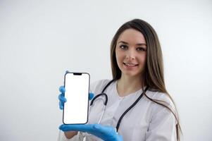 portret van medisch dokter vrouw met stethoscoop en telefoon in handen. geïsoleerd Aan wit achtergrond. foto