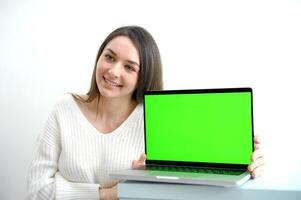 jong vrouw toepassingen laptop groen scherm chroma sleutel terwijl zittend in appartement foto