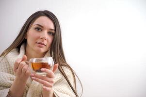 portret van een aantrekkelijk jong blond vrouw Holding een heet kop van thee. foto