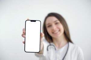mooi vrouw dokter tonen een slim telefoon scherm geïsoleerd geïsoleerd Aan een wit achtergrond foto