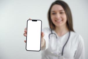 portret van gelukkig jong vrouw dokter tonen mobiele telefoon foto