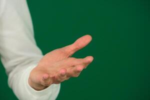 leeg hand- palm omhoog gebaar geïsoleerd Mens vent Aan een groen achtergrond Chroma sleutel detailopname donker haar- jong Mens. wit sweater foto