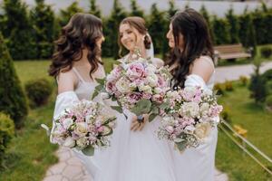 drie Dames zijn Holding boeketten van bloemen en poseren voor een afbeelding foto