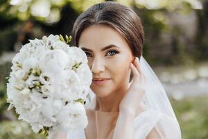 een vrouw is poseren met een boeket van wit bloemen in haar hand- foto