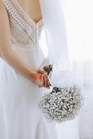 een bruid is Holding een boeket van wit bloemen foto