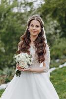 een vrouw vervelend een wit jurk en Holding een boeket van bloemen foto