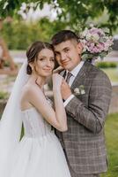 een bruid en bruidegom zijn poseren voor een afbeelding met een boeket van bloemen foto