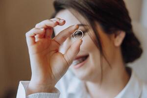 een vrouw is Holding een ring in haar hand- en glimlachen foto