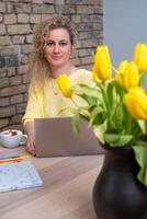 de helder sfeer van een creatief werkruimte is gevangen genomen door een vrouw met een vriendelijk gedragswijze, omringd door vrolijk tulpen, symboliseert een bloeiend carrière of bedrijf. foto