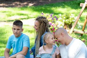 gevangen genomen in een natuurlijk park instelling, een familie geniet de warmte van saamhorigheid, vieren de vreugden van nationaal broers en zussen dag en ouderlijk liefde met actief rust uit en verloving. foto