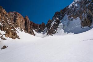 bergbeklimmers moeilijk alpine beklimming omhoog steil ijzig kliffen. expeditie stijgt met Super goed risico naar steil piek. besneeuwd gletsjer, hoog bergen. alpen, hiking, klimmen. extreem stijgen van sterk mensen foto