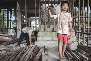 arm kinderen werk in bouw sites omdat van armoede, kind arbeid, menselijk mensenhandel, wereld dag tegen kind arbeid concept. foto