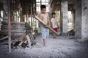 twee arm kinderen zijn gedwongen naar werk in bouw. arm kinderen, armoede, kind arbeid, wereld dag tegen kind arbeid concept. foto