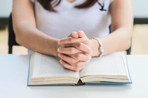 jong vrouw geklemd haar handen samen in gebed vragen voor vergiffenis van god gebaseerd Aan haar christen overtuigingen en geloof in god leringen. concept gebed en voorspraak volgens overtuigingen over god foto