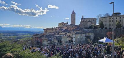 monforte d'alba, cuneo, Italië. april, 01, 2024.groep van feestelijk en vrolijk mensen vieren Pasen maandag in monforte d'alba, in de historisch centrum, aan het eten en drinken in bedrijf foto