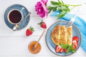 gastronomisch ontbijt. heerlijke zoete gebakken pannenkoeken met verse aardbeien. foto